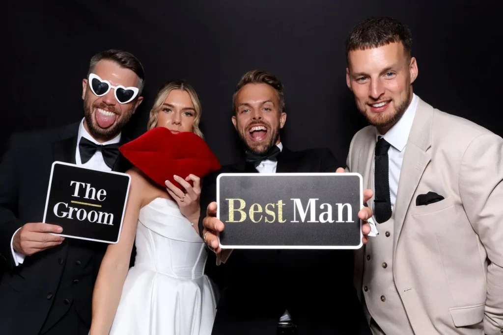 Bride and guests posing for a photo booth photo holding up word signs