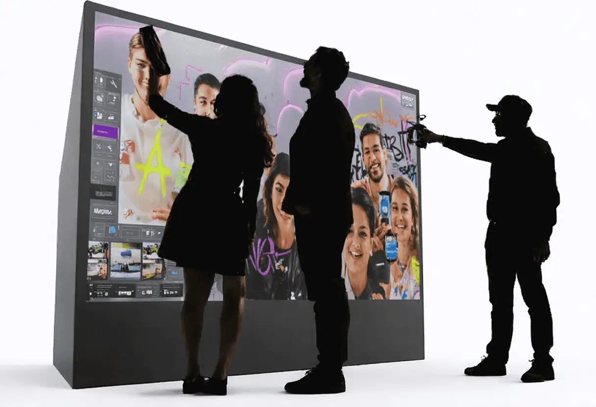 Three people interact with a large digital touchscreen, drawing colourful images as silhouettes are visible in the brightly lit scene. This setup is perfect for corporate event experiential activities or as part of a premium photo booth hire.