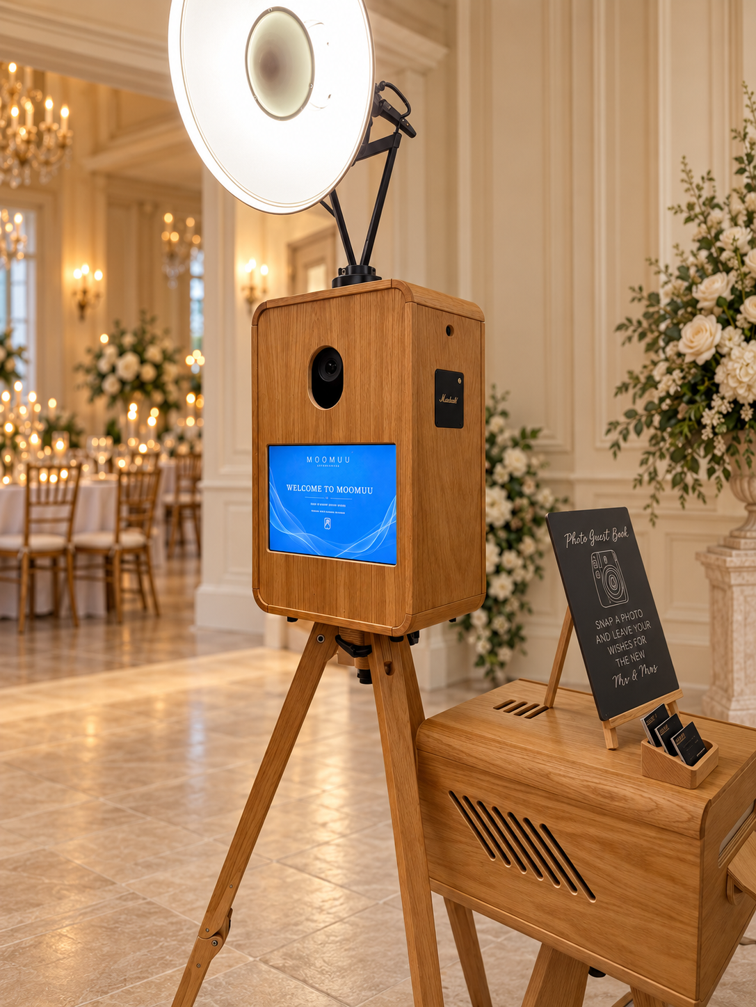 Front of the MooMuu ICON oak photo booth with camera, touchscreen and studio lighting in an elegant venue.