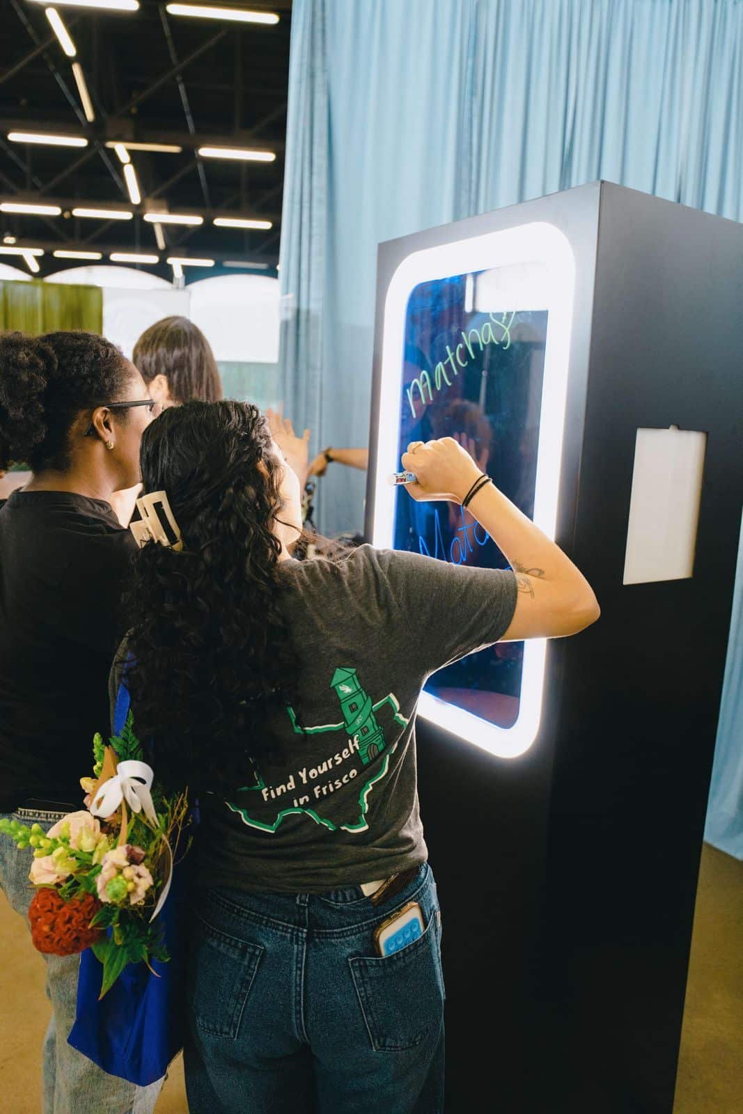 Guests writing personalised messages on the illuminated Scribble Booth at an event