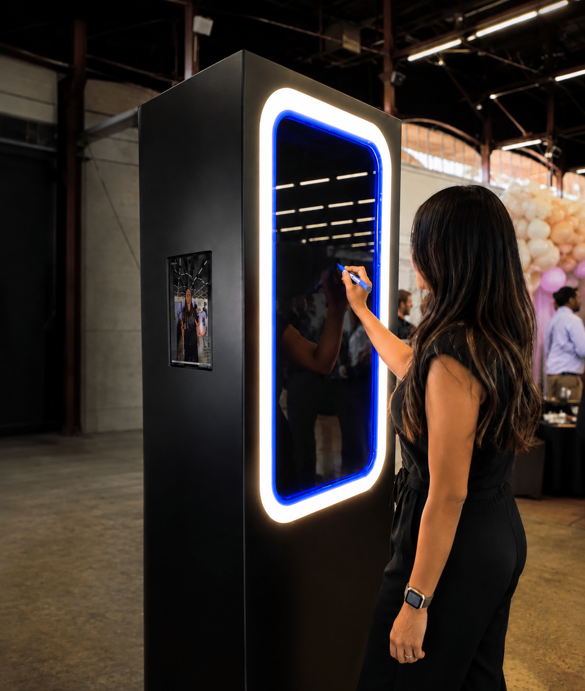 Guest drawing on the illuminated Scribble Booth mirror at an event